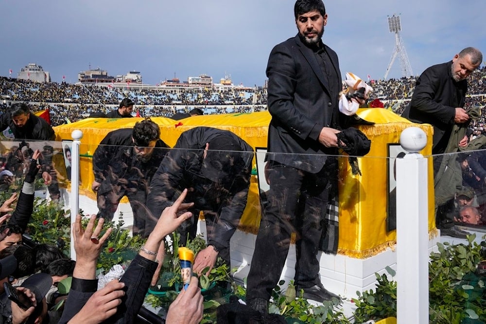 A trailer carrying the coffins of Hezbollah leaders Sayyed Hassan Nasrallah and Sayyed Hashem Safieddine drives through the crowd a the beginning of a funeral procession in the Sports City Stadium in Beirut, Lebanon, Sunday, Feb. 23, 2025 (AP)