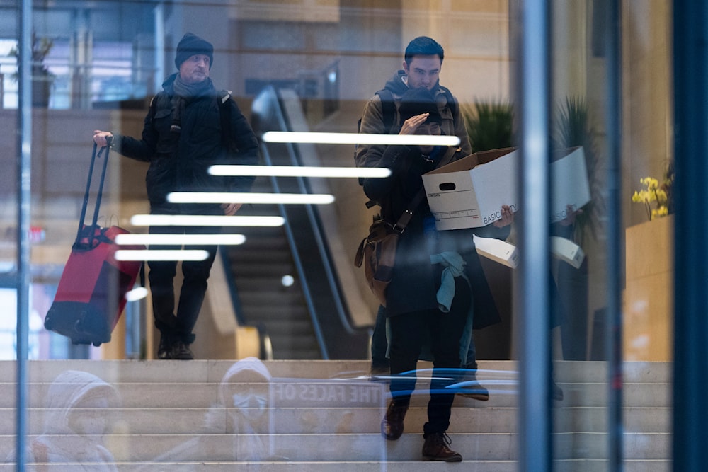 A group of United States Agency for International Development workers, carry their personal belongings after retrieving them from the USAID's Bureau of Humanitarian Affairs office, in Washington, Friday, Feb. 21, 2025, in Washington. (AP)
