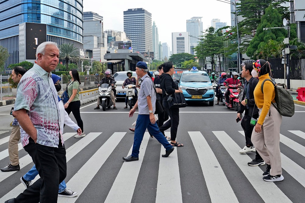 People walk on a pedestrian crossing at the main business district in Jakarta, Indonesia, Tuesday, Jan. 7, 2025. (AP)