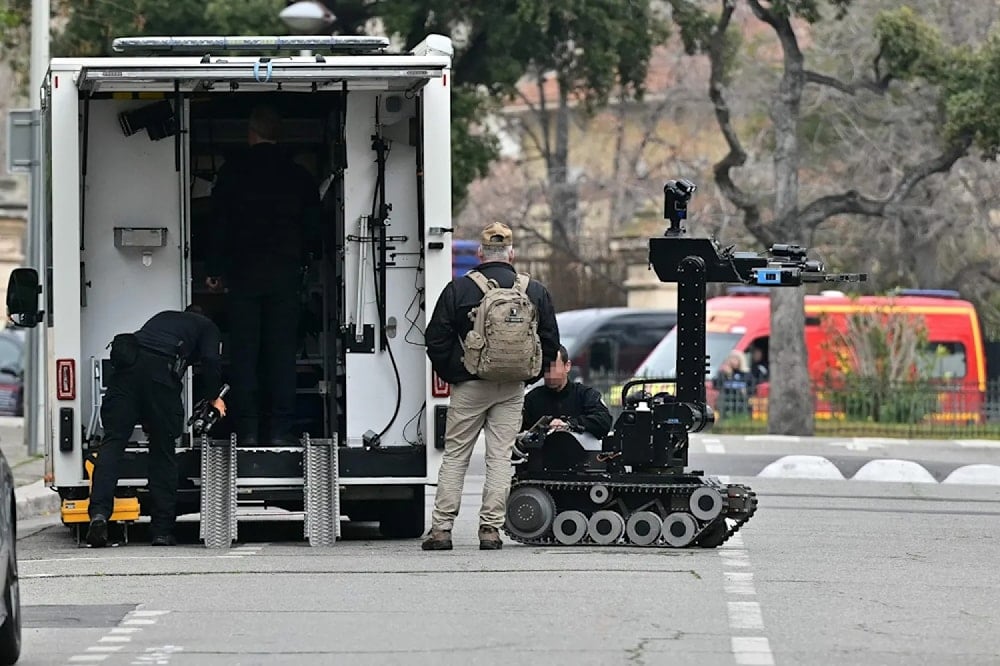 Bomb-squad officers prepare a demining robot in front of the Russian consulate in Marseille, after improvised explosive devices were thrown, on February 24, 2025. (AFP)