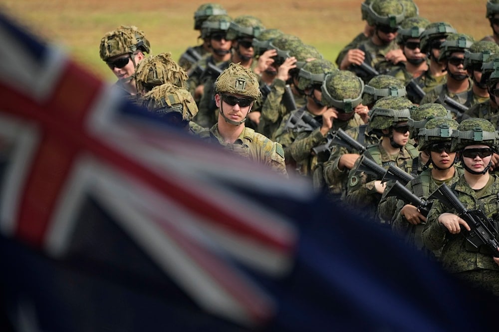 The Australian flag flies in front of Australian and Philippine troops during opening ceremonies for army-to-army bilateral exercises called 