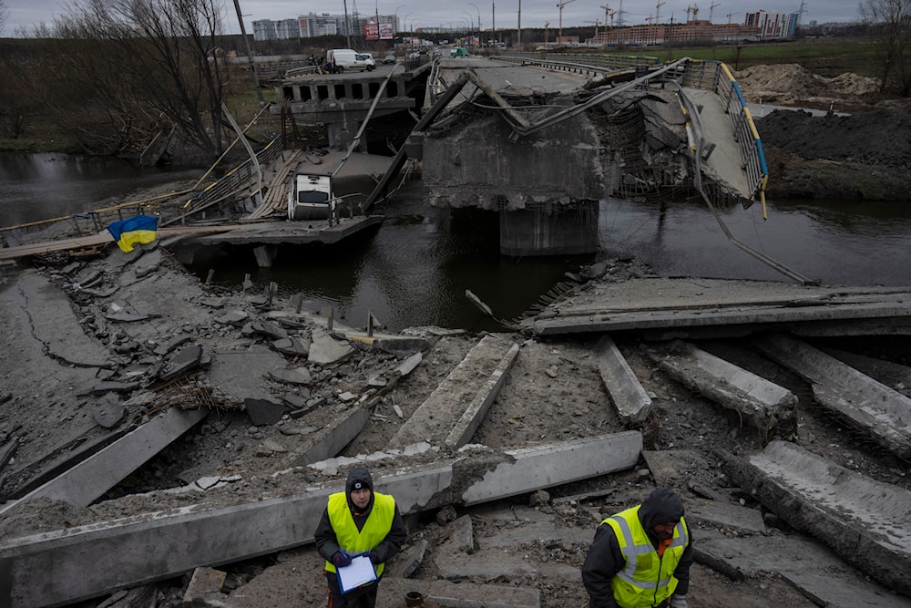 Engineers inspect the state of destruction of the bridge that connects Kiev with Irpin, Ukraine, Wednesday, April 13, 2022. (AP)