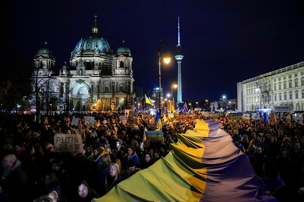 People hold a huge Ukrainian flag as they attend a demonstration against Russia's war on Ukraine as they mark the third anniversary of the full-scale invasion in Berlin, Monday, Feb. 24, 2025. (AP)