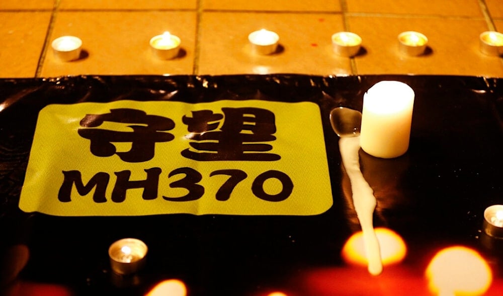 A banner is displayed during a candlelight vigil for passengers onboard the missing Malaysia Airlines Flight MH370, in Kuala Lumpur, Malaysia, Monday, April 7, 2014. (AP)