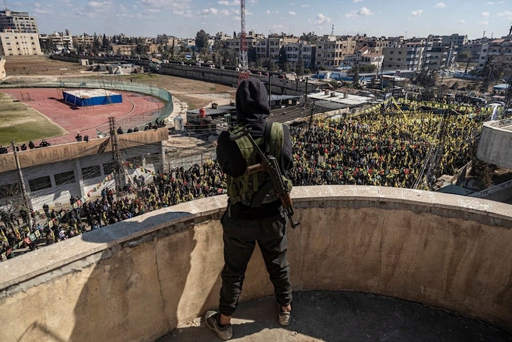 A Syrian Democratic Forces (SDF) fighter watches as hundreds of demonstrators march to demand the release of Kurdish leader Abdullah Ocalan in Qamishli, northeastern Syria, Saturday Feb. 15, 2025 (A)