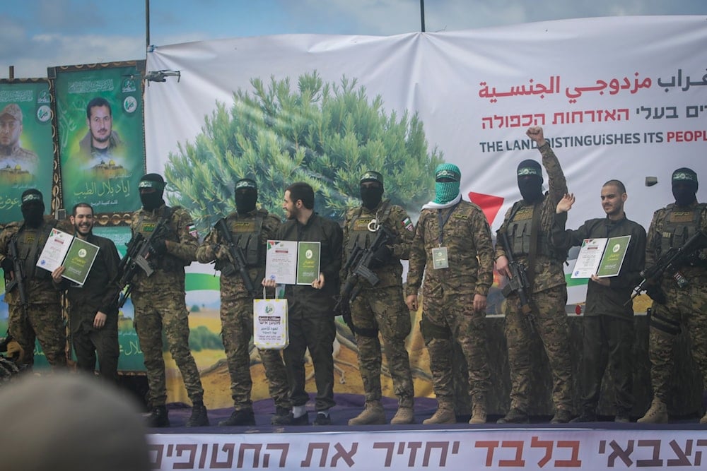 Israeli captives, from left to right, Eliya Cohen, Omer Shem and Omer Wenkert, show Hamas issued certificates as instructed by militants, before being handed over to the Red Cross in Nuseirat, central Gaza Strip, Saturday, Feb. 22, 2025 (AP)