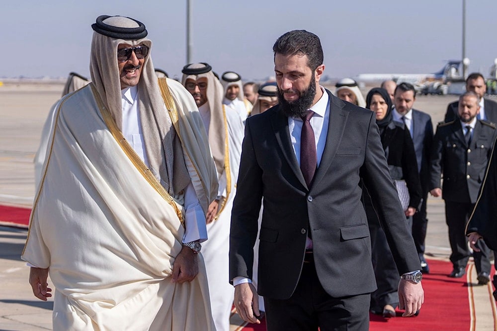 This photo released by Qatar news agency, shows Qatar's Emir Sheikh Tamim bin Hamad al-Thani, left, welcomed by Syria's interim President Ahmad al-Sharaa, upon his arrival at the airport in Damascus, Syria, on January 30, 2025. (Qatar news agency via AP)