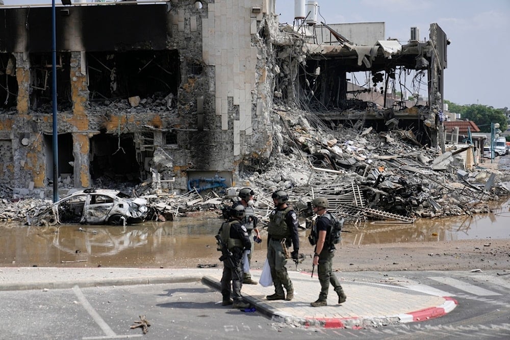 Israeli police retrieve weapons used by Resistance fighters outside a police station in Sderot, occupied Palestine, Sunday, Oct. 8, 2023 (AP)