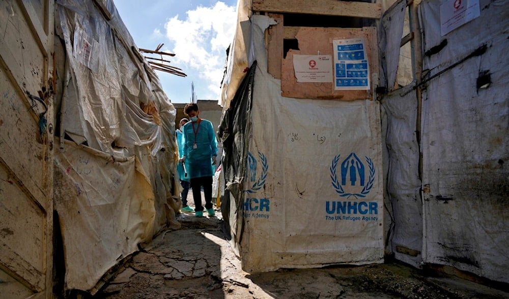 UNICEF health workers sanitize tents as part of their cholera outbreak containment response, at a Syrian refugee camp in Bhanine village, in the northern Akkar province, Lebanon, Tuesday, Oct. 18, 2022. (AP)