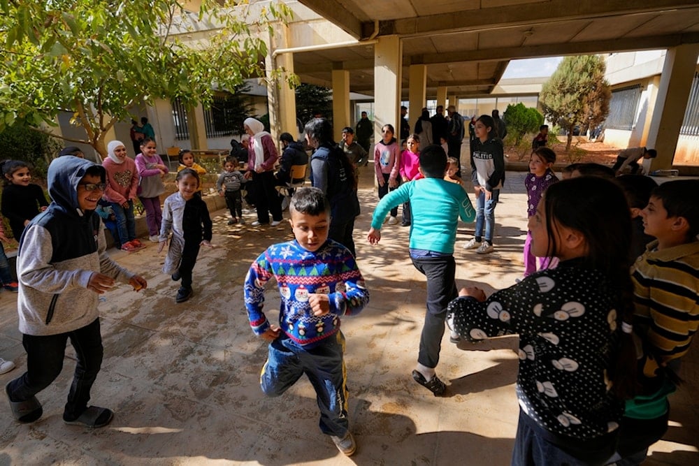 Displaced children, who fled Baalbek city and the nearby towns of Douris and Ain Bourday with their families amid the war on Lebanon, play at a school being used as a shelter, in Deir Al-Ahmar, east Lebanon, Thursday, Oct. 31, 2024 (AP)