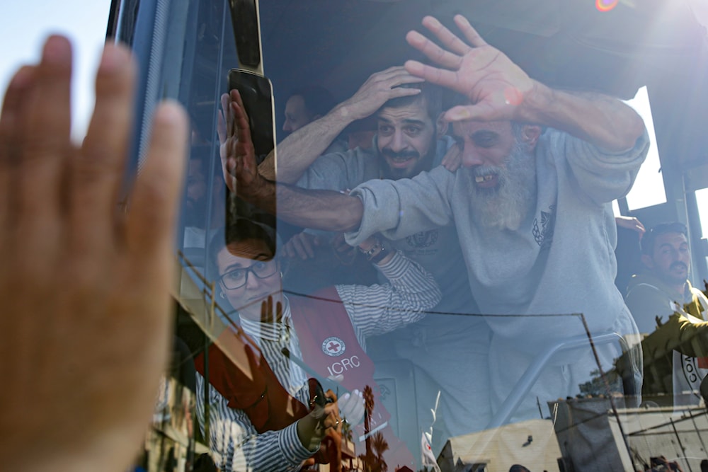 Freed Palestinian prisoners wave from a bus as they arrive in the Gaza Strip after being released from Israeli prison. Saturday Feb. 1 (AP)