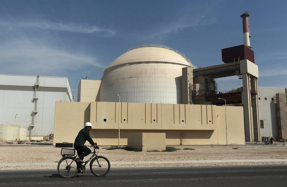 A worker rides a bicycle in front of the Bushehr nuclear plant in Iran. Oct. 26, 2010 (AP)