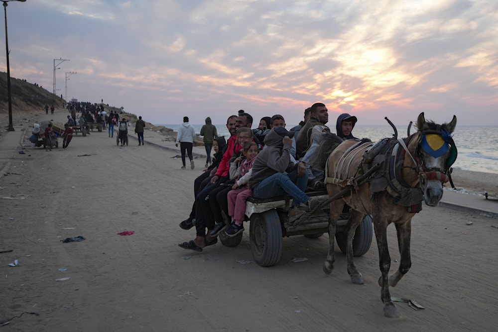 Displaced Palestinians ride on a horse-drawn cart as they return to their homes in the northern Gaza Strip, Tuesday, Jan. 28, 2025. (AP)