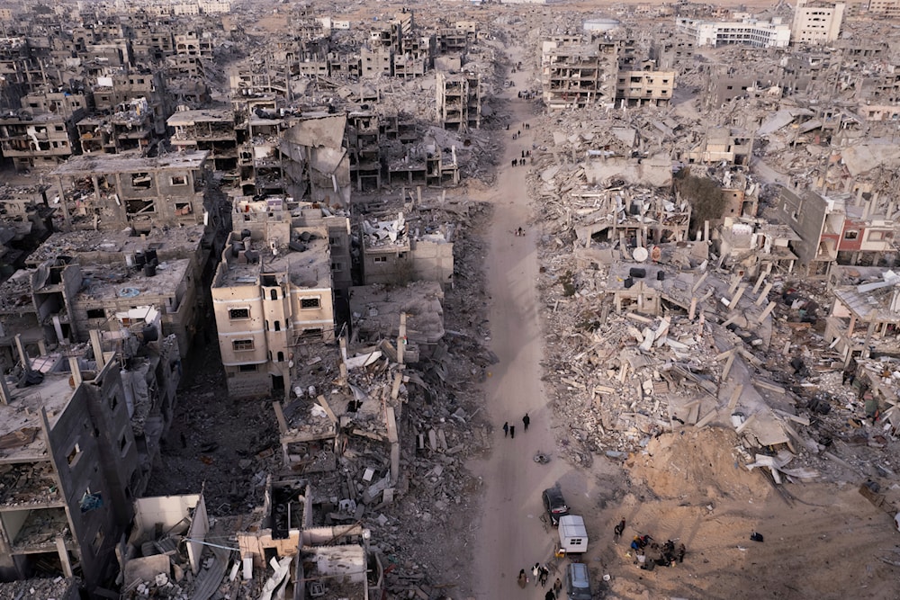 An aerial photograph taken by a drone shows Palestinians walking through the destruction caused by the Israeli air and ground offensive, in Rafah, Gaza Strip, Tuesday, Jan. 21, 2025. (AP)