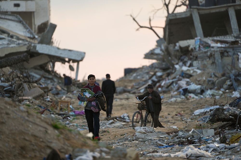 Palestinians walk along a street in Gaza City, surrounded by rubble from buildings destroyed during the Israeli army's ground and air offensive against Hamas. Tuesday, Feb. 4, 2025 (AP)