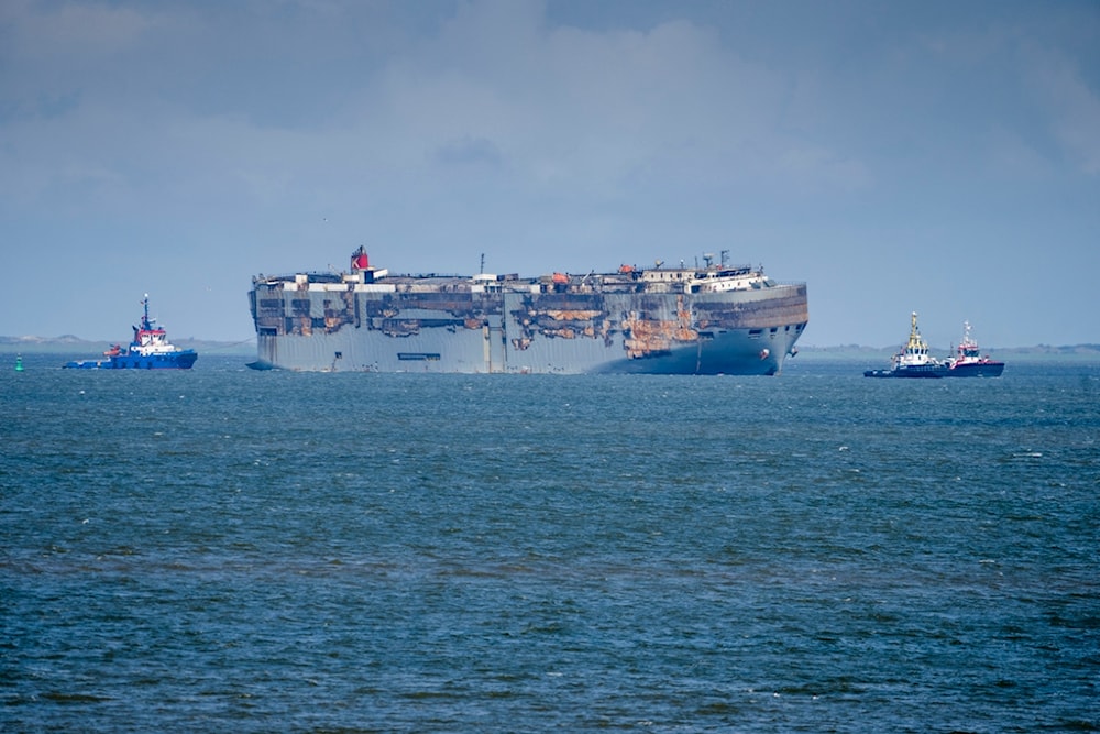 Stricken cargo ship Fremantle Highway is towed after catching fire into the port of Eemshaven, the Netherlands, on Thursday, Aug. 3, 2023 (AP)