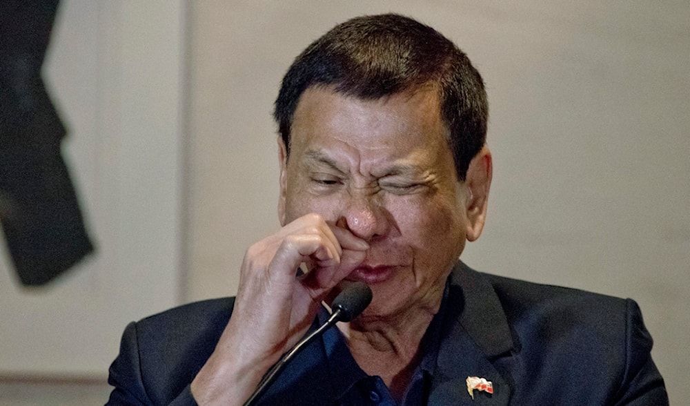Philippine President Rodrigo Duterte demonstrates how a drug addict sniffs drugs during a press conference in Beijing, China, Wednesday, Oct. 19, 2016. (AP)