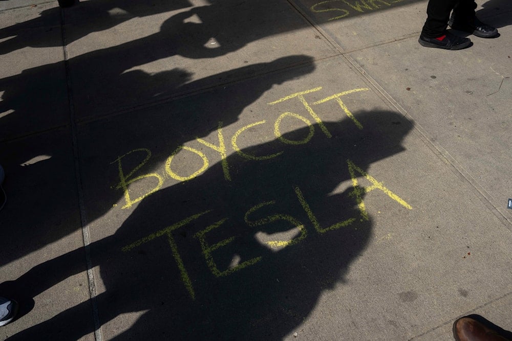 A 'Boycott Tesla' message is drawn on the floor during a protest against Elon Musk and Tesla outside of a Tesla showroom, Saturday, March 01, 2025 in New York. (AP)