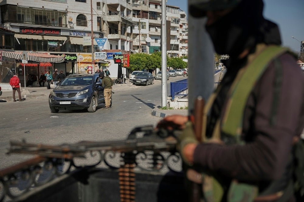 Syrian security forces inspect vehicles at a checkpoint in Latakia, in Syria's coastal region, Tuesday, March 11, 2025 (AP)
