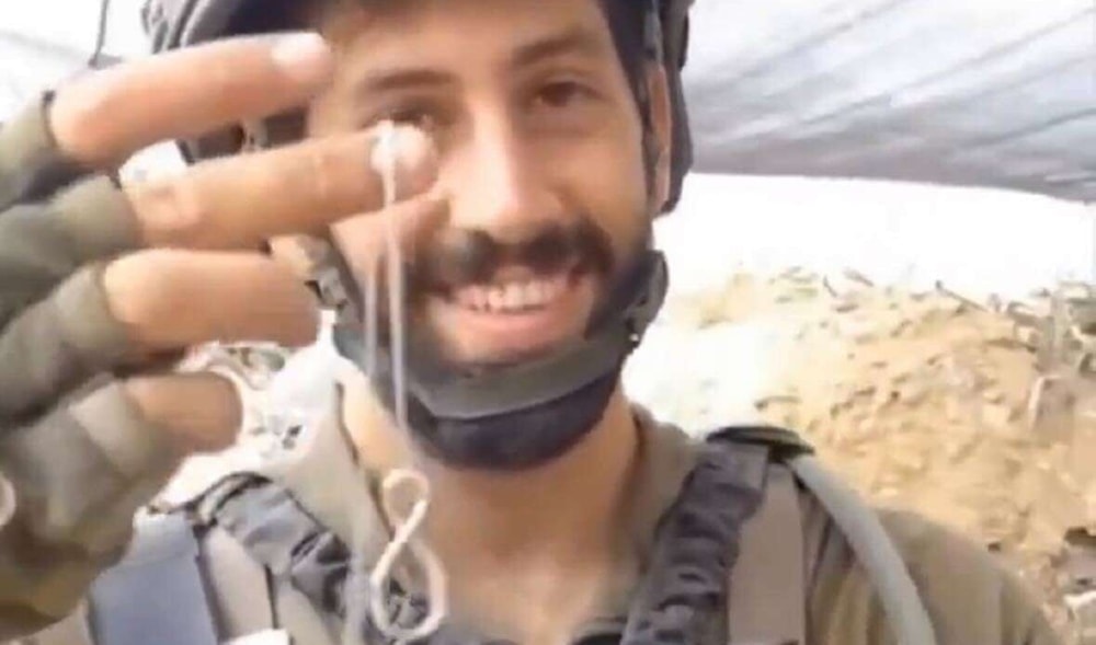  A screen grab from a video, featuring an Israeli soldier displaying a silver necklace with the inscription Made in Gaza, which he pledged to give to his girlfriend. (Twitter)