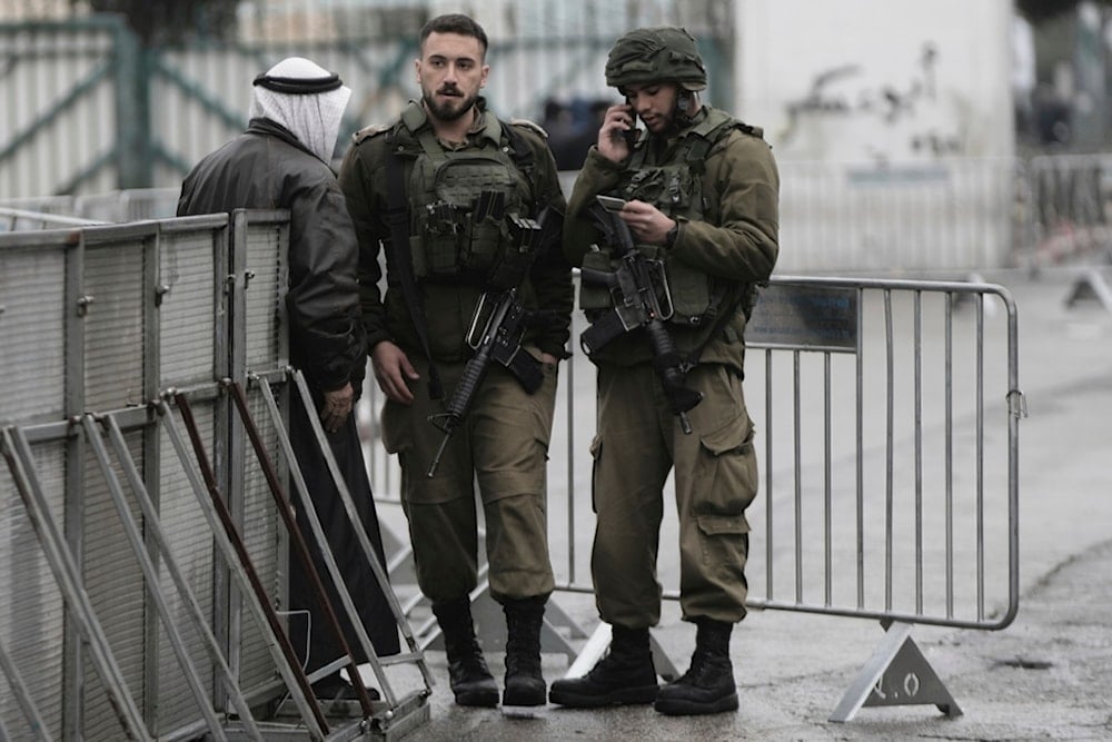 Israeli soldiers check a Palestinian man's ID at a checkpoint in the West Bank city of Beit Lahm on his way to the al-Aqsa Mosque compound in occupied al-Quds, Friday, March 7, 2025 (AP)