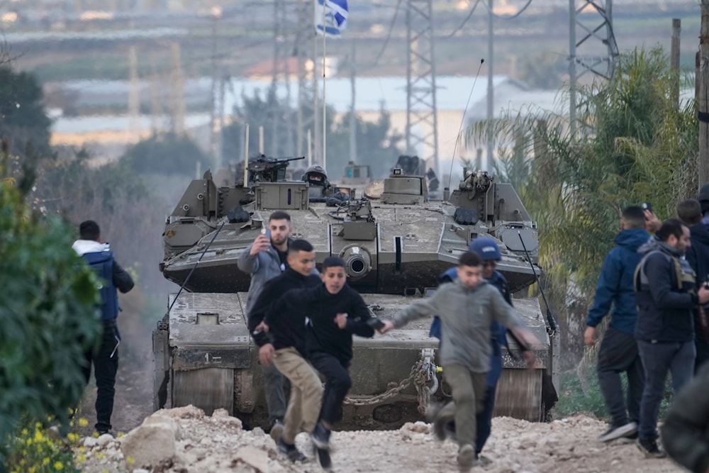 Palestinian children run as Israeli soldiers drive a tank towards the occupied West Bank of Jenin camp, during a raid, Feb. 23, 2025. (AP Photo/Majdi Mohammed)
