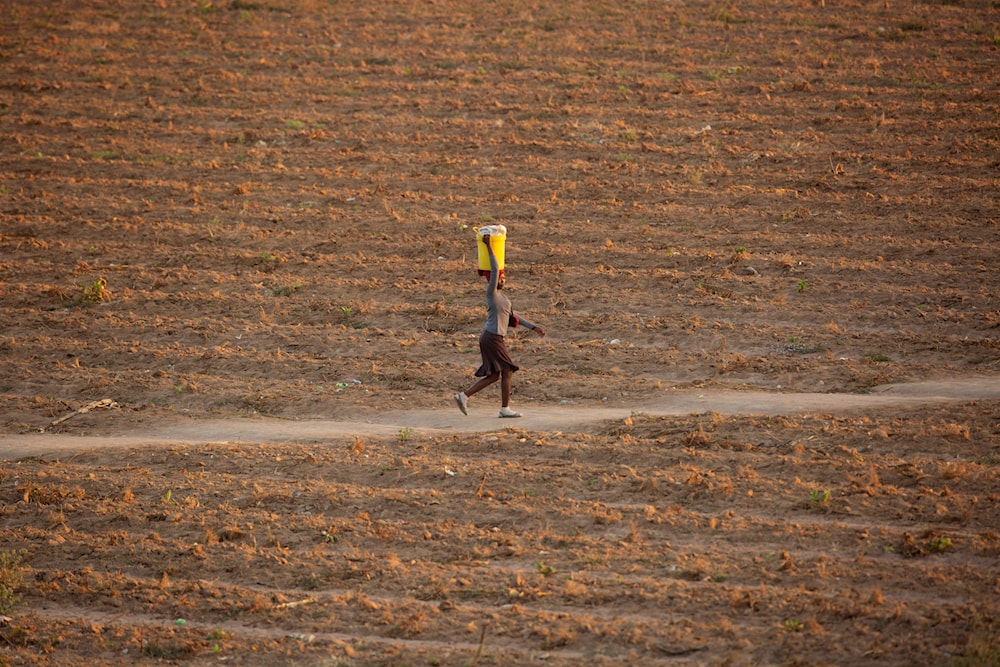 A woman walks along a path in a drought-stricken field in Zvimba, rural Zimbabwe, Saturday, June, 26, 2021. (AP)