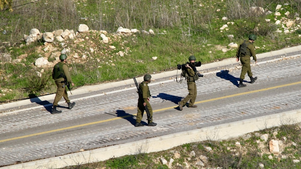 This picture taken from Lebanon's southern village of Shaqra on January 25, 2025 shows Israeli army soldiers walking along a road at the entrance of the village of Hula along the border with Israel in south Lebanon. © AFP