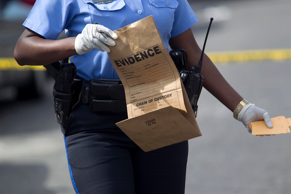 New Orleans police officer collects evidence at the scene of a shooting at the intersection Frenchman Street at N. Villere on Mother's Day in New Orleans, Sunday May 12, 2013. (AP)