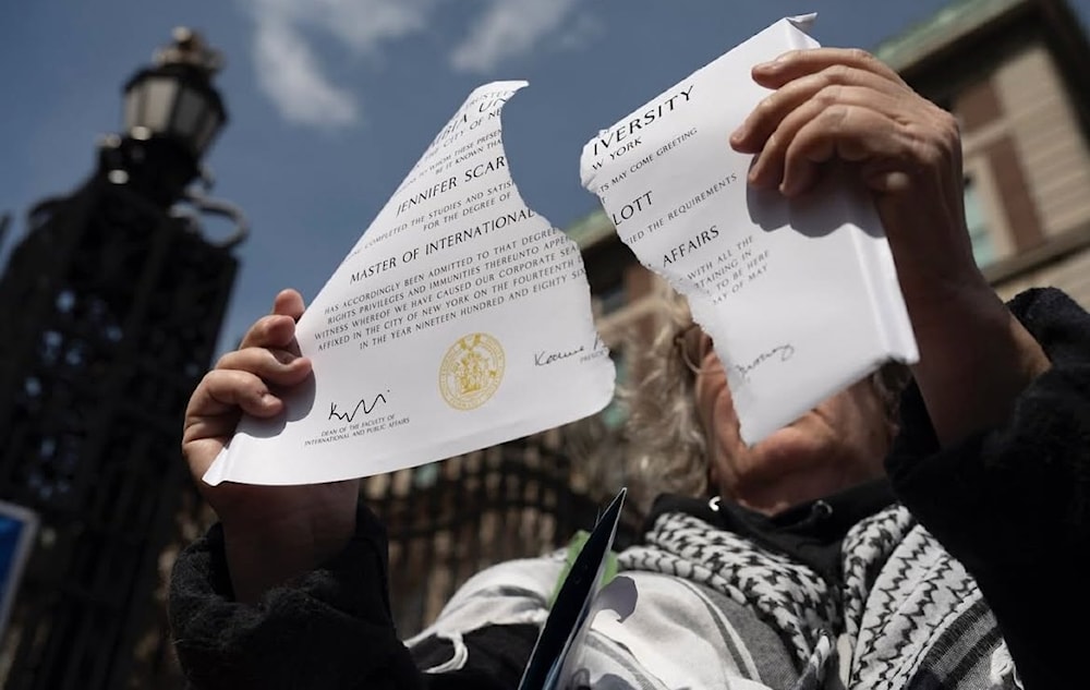 Columbia University alumni gathered to protest the kidnapping of Mahmoud Khalil, the collaboration between Columbia trustees and ICE, and the ongoing genocide in Gaza. Alumni ripped up their diplomas. (Photos taken by Nina Berman/social media)