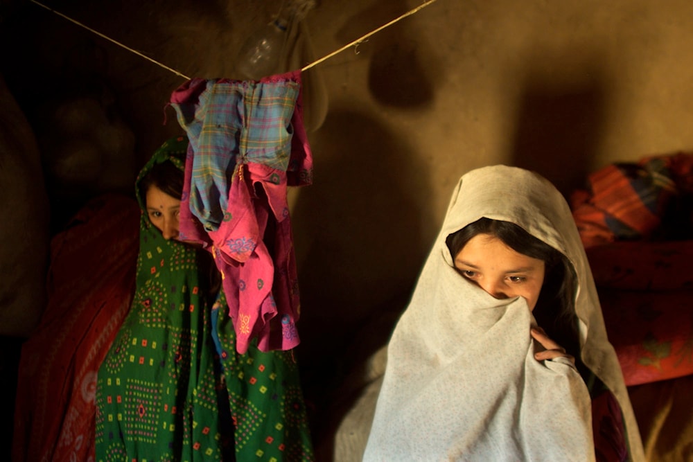 Najeeba Mugal, 13, right, and her sister Laleema, Afghan refugees who arrived in Quetta from Afghanistan with their family earlier in the week, stand in the four-square-meter mud house they seeked refuge in Friday Sept. 28 2001. (AP)