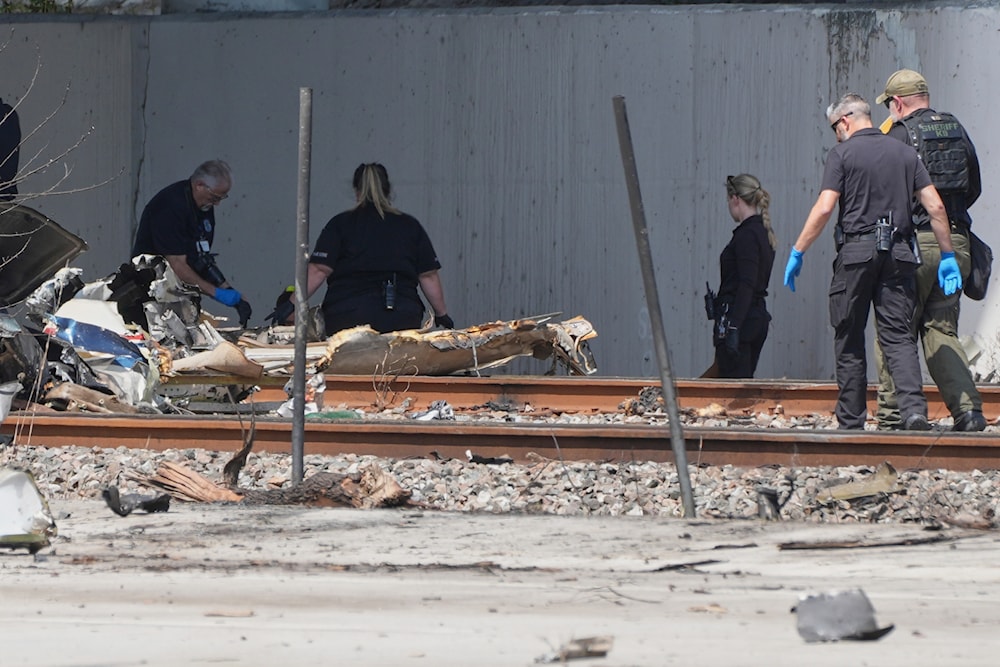 Emergency personnel respond to the area where a small plane crashed on the railroad tracks beneath the overpass near Interstate 95 in Boca Raton, Fla., on Friday, April 11, 2025. (AP)