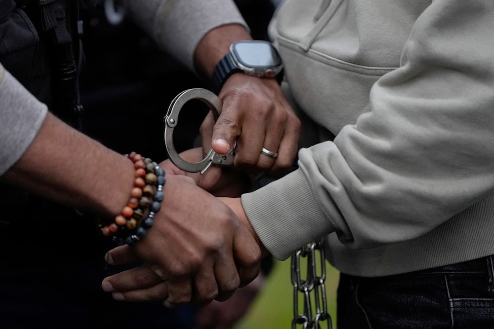  A US deportation officer changes the handcuffs of Wilmer Patricio Medina-Medina from back to front after arresting him during an early morning operation, Dec. 17, 2024, in the Bronx borough of New York. (AP)