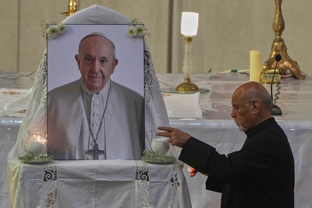 An Egyptian priest lights a candle during a service for the late Pope Francis at Holy Virgin Mary Coptic Catholic Cathedral, in Cairo, Egypt, Tuesday, April 22, 2025 (AP)