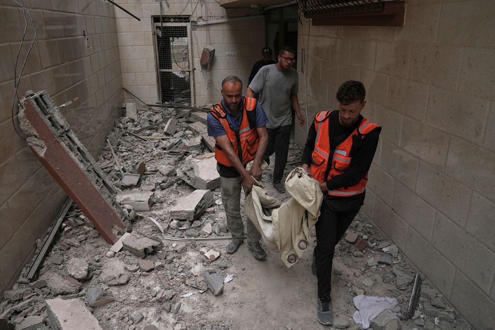 Palestinian civil defense workers carry the remains of a person killed during an Israeli airstrike on a residential building in Gaza City, Thursday, April 24, 2025. (AP)