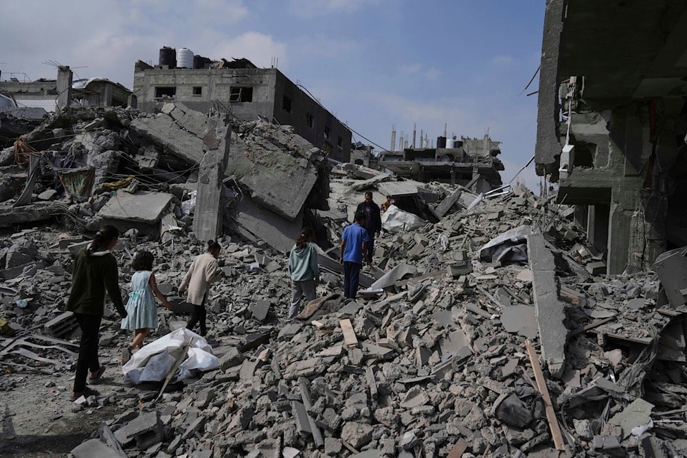 Palestinians walk in the rubbles after an Israeli army airstrike in Beit Lahia, northern Gaza Strip, Monday, April 28, 2025. (AP)
