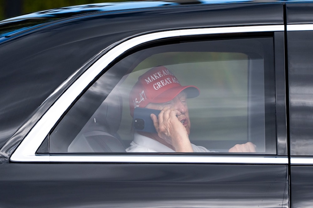 US President Donald Trump talks on the phone as he arrives at the Trump International Golf Club, Friday, April 4, 2025, in West Palm Beach, Florida (AP)