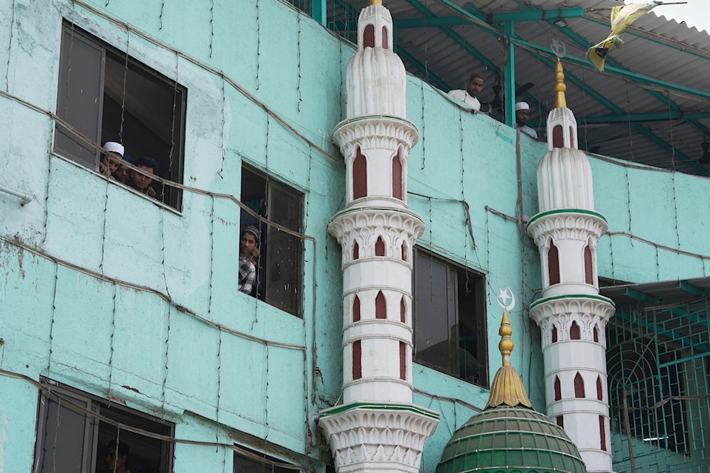 Muslim individuals gaze out the window after performing the afternoon prayers at the mosque in Mumbai, India, Friday, April. 4, 2025 (AP)
