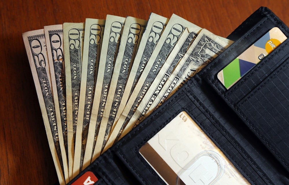 Cash is fanned out from a wallet in North Andover, Mass (AP)