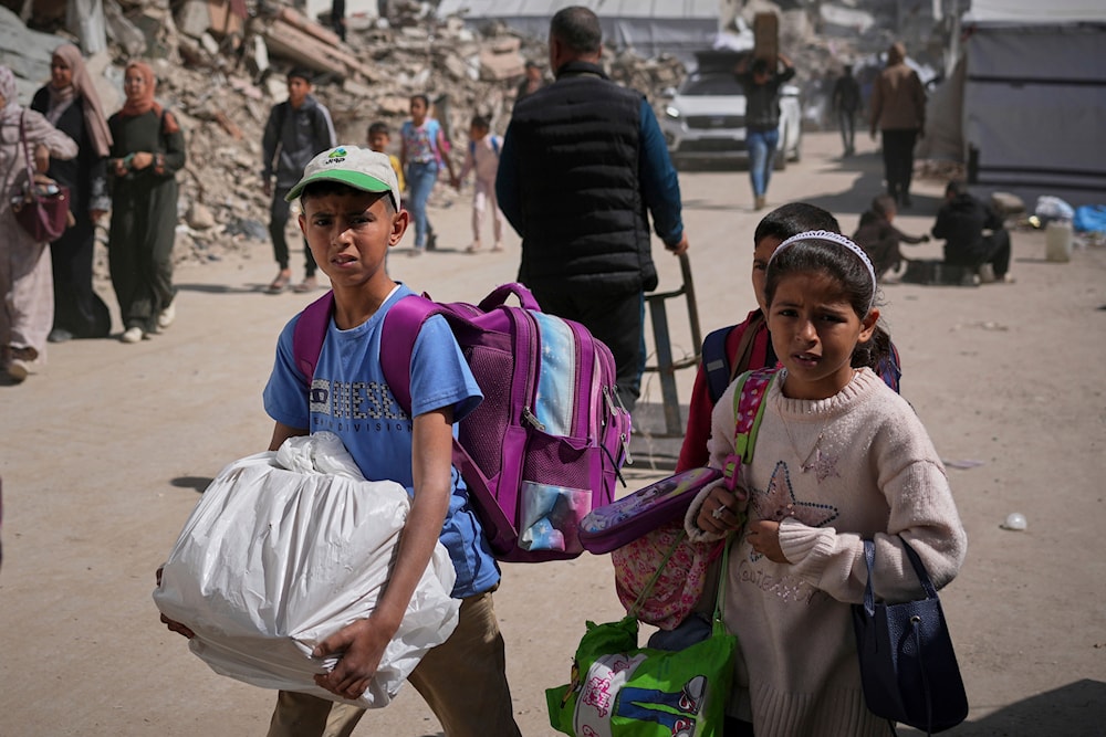 Traumatized Palestinian children carry belongings as they are forcibly displaced from the Shijaiyah neighborhood following evacuation warnings issued by the Israeli army, in Gaza City,on Thursday, April 3, 2025. (AP Photo/Jehed Alshrafi)