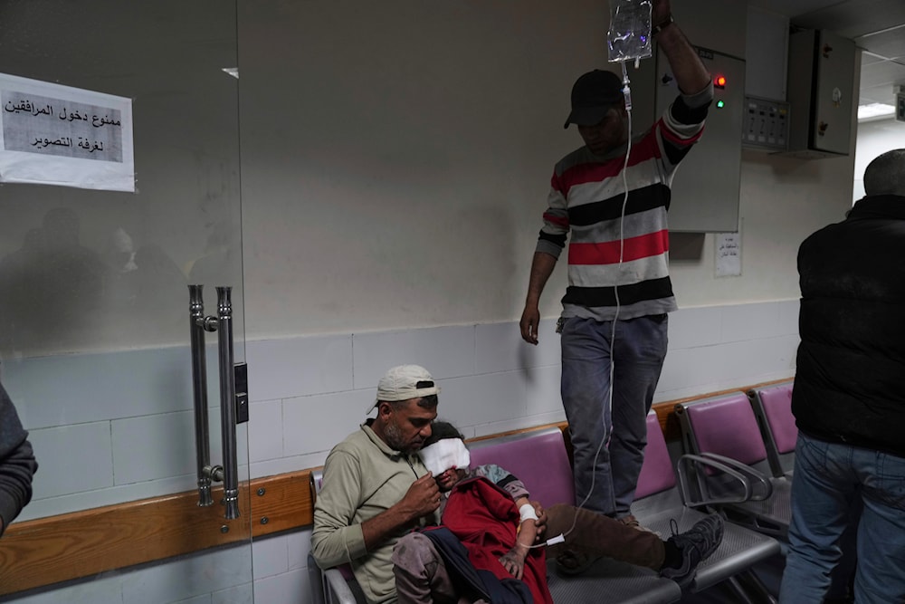 A Palestinian father holds his child who was severely injured in an Israeli airstrike at the Baptist Hospital in Gaza City, April 3, 2025. (AP)