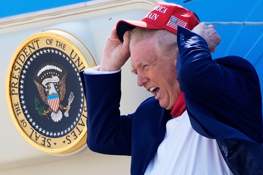 President Donald Trump holds his hat in the wind as he arrives on Air Force One at Selfridge Air National Guard Base, Tuesday, April 29, 2025, in Harrison Township, Mich. (AP Photo/Alex Brandon)