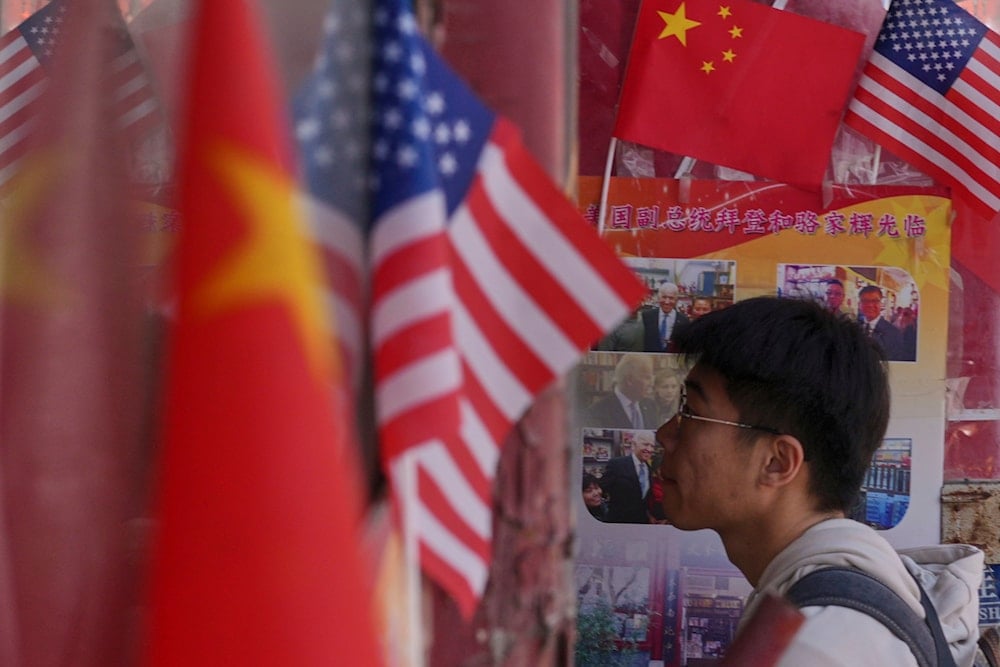 A man walks into a merchandise store displaying Chinese and United States' national flags, in Beijing, Thursday, April 3, 2025 (AP)