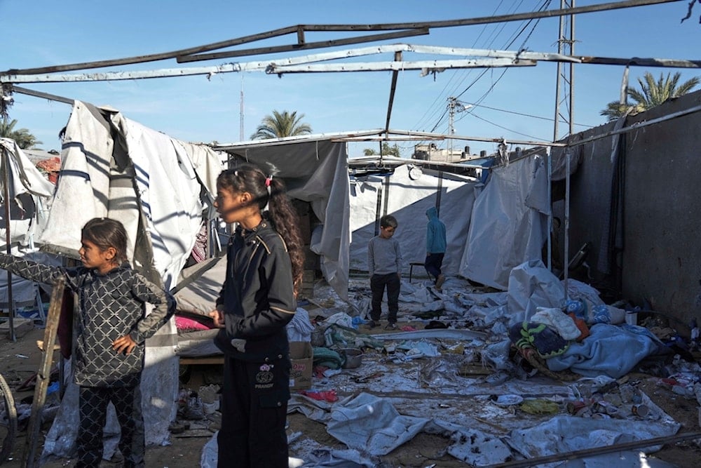 Palestinians inspect the damage caused by an Israeli airstrike that targeted displacement tents in Deir al-Balah, in the central Gaza Strip, Wednesday, May 7, 2025 (AP)