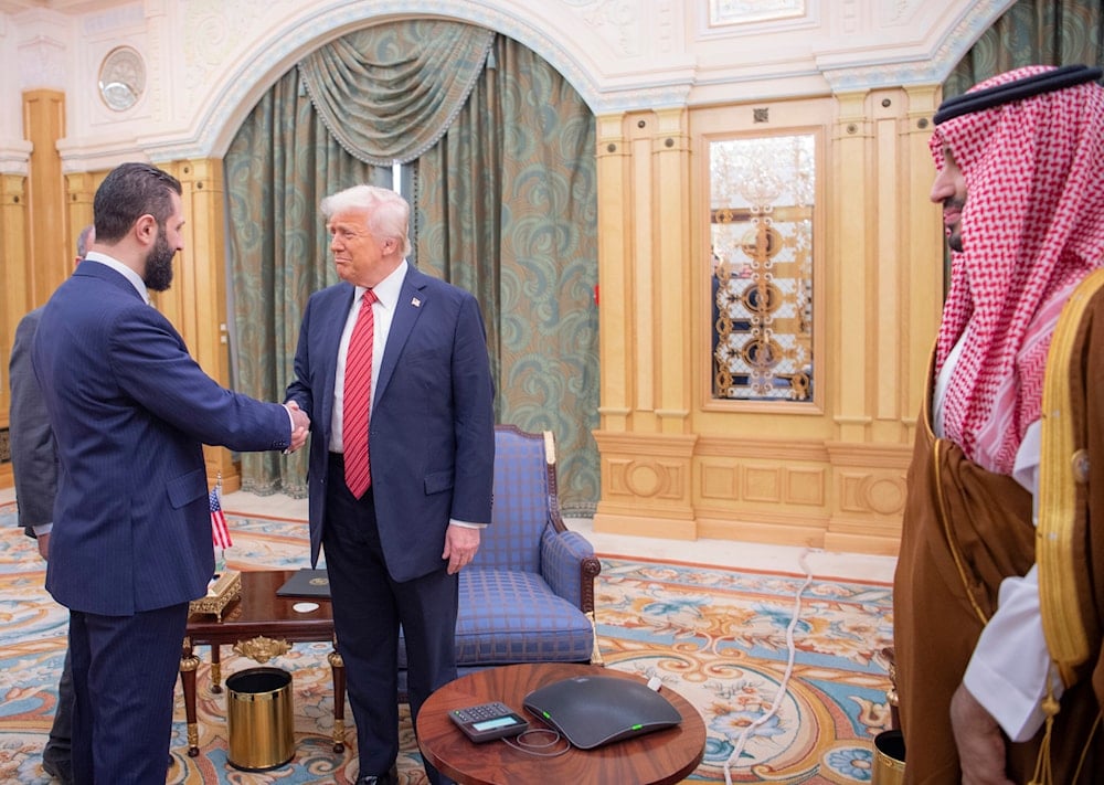 In this photo released by the Saudi Royal Palace, Syria's interim President Ahmad al-Sharaa, left, shakes hands with President Donald Trump, centre, in Riyadh, Saudi Arabia, Wednesday, May 14, 2025 (AP)