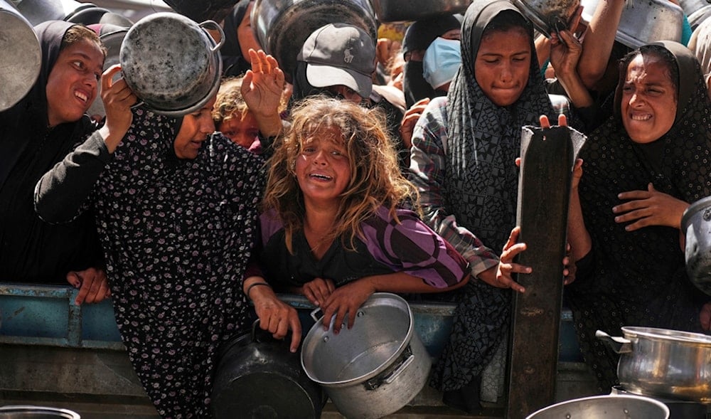 Palestinians struggle to get donated food at a community kitchen in Khan Younis, Gaza Strip, Friday, May 16, 2025. (AP)