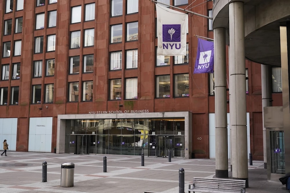 Pedestrians walk near an NYU building in New york, December 16, 2021 (AP/Seth Wenig)