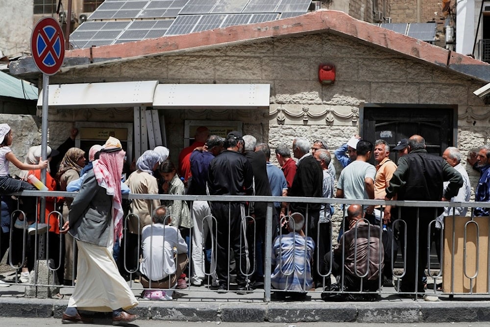Syrians line up to retrieve money from an ATM in Damascus, Syria, Wednesday, May 14, 2025 (AP)