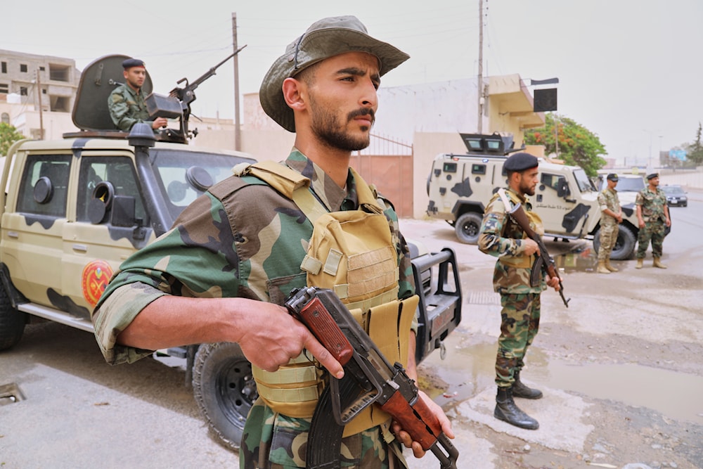 A Libyan soldier stands alert at a checkpoint after clashes between heavily armed militias following the killing of a powerful warlord, in Tripoli, Libya, Thursday, May 15, 2025 (AP)