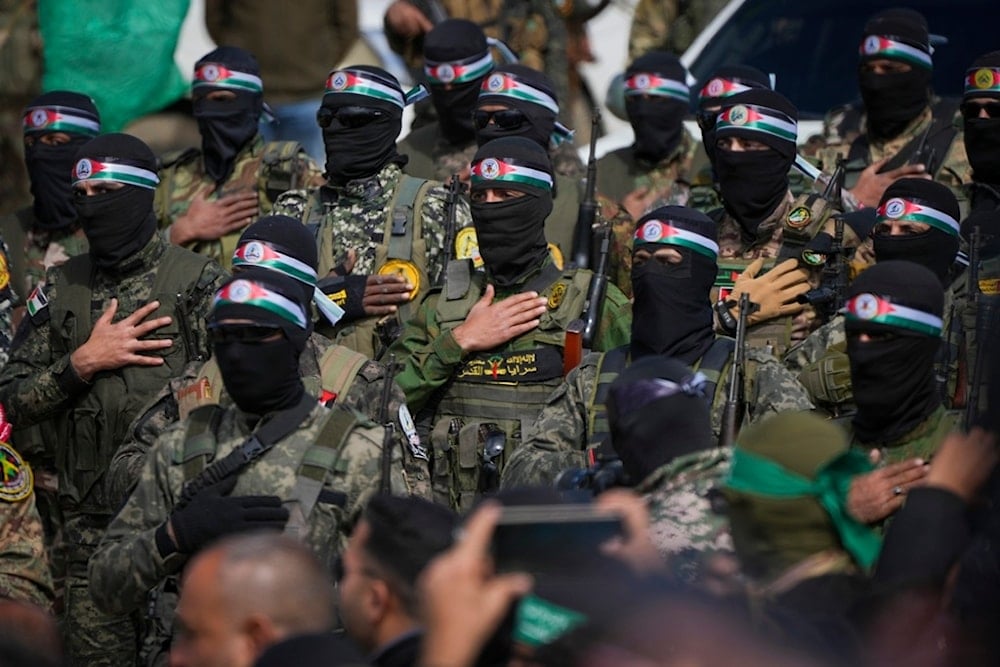 Hamas fighters stand in formation ahead of a ceremony to hand over Israeli captives to the Red Cross in Nuseirat, Gaza Strip, February 22, 2025 (AP)